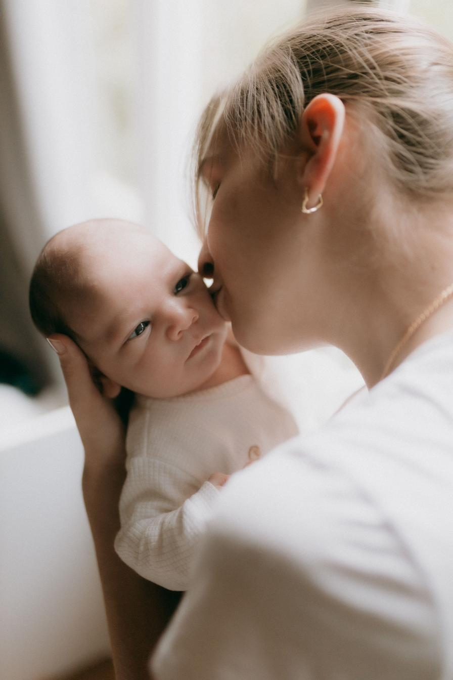 Mother kissing her baby's cheek