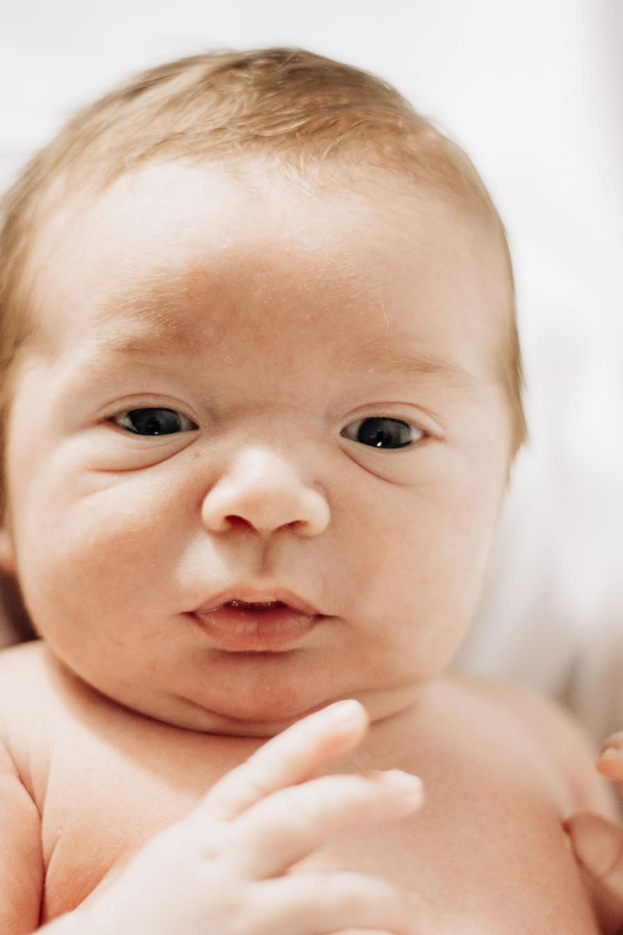 Wide-eyed newborn looking up